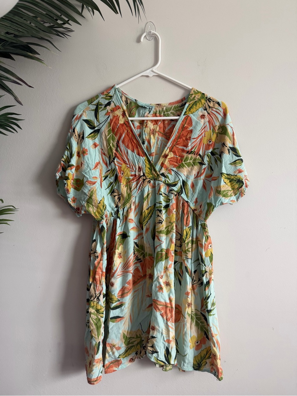 LV-neck mini dress featuring a vibrant tropical leaf and floral print in shades